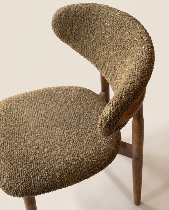 t4option0_5 | A mid-century modern side chair featuring a textured, shaggy olive green upholstered seat and backrest, supported by four tapered walnut wooden legs, set against a solid off-white background.