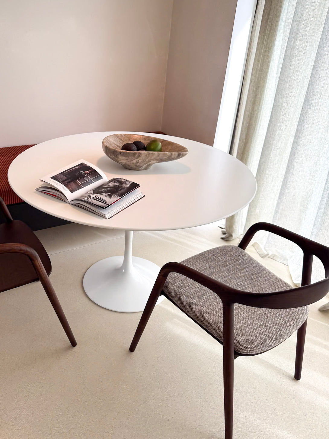 Walnut chair with upholstered fabric, in a minimalist, modern setting. Belgian-based furniture