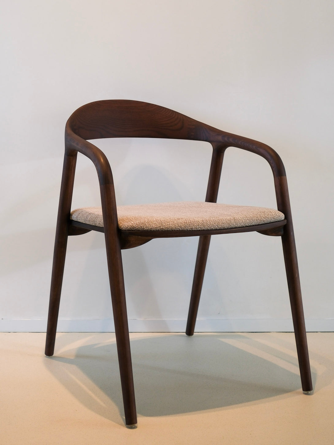 Wooden chair with a beige cushion in a modern setting