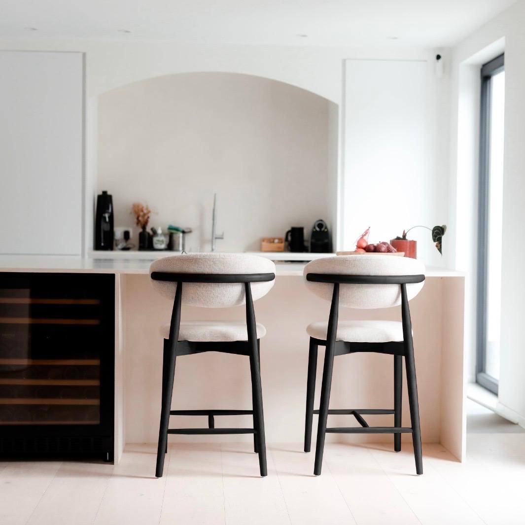 Back view of two Mowelli Dianne bar stools in black wood and minimalist design at a European kitchen island