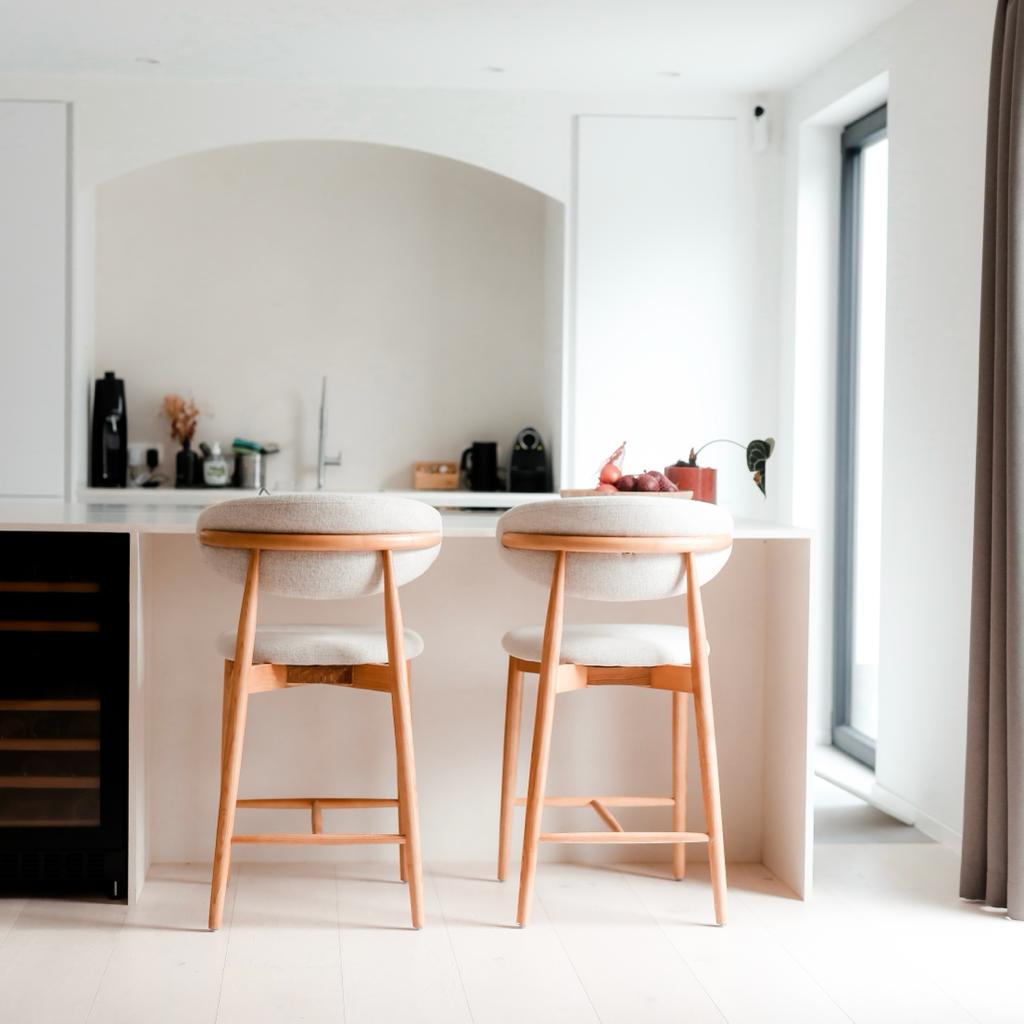 Back view of two Mowelli Dianne bar stools in natural wood and minimalist design at a European kitchen island