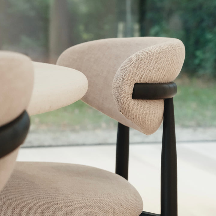 Mowelli Dianne dining chair in black wood and beige fabric, captured in natural daylight for true color representation