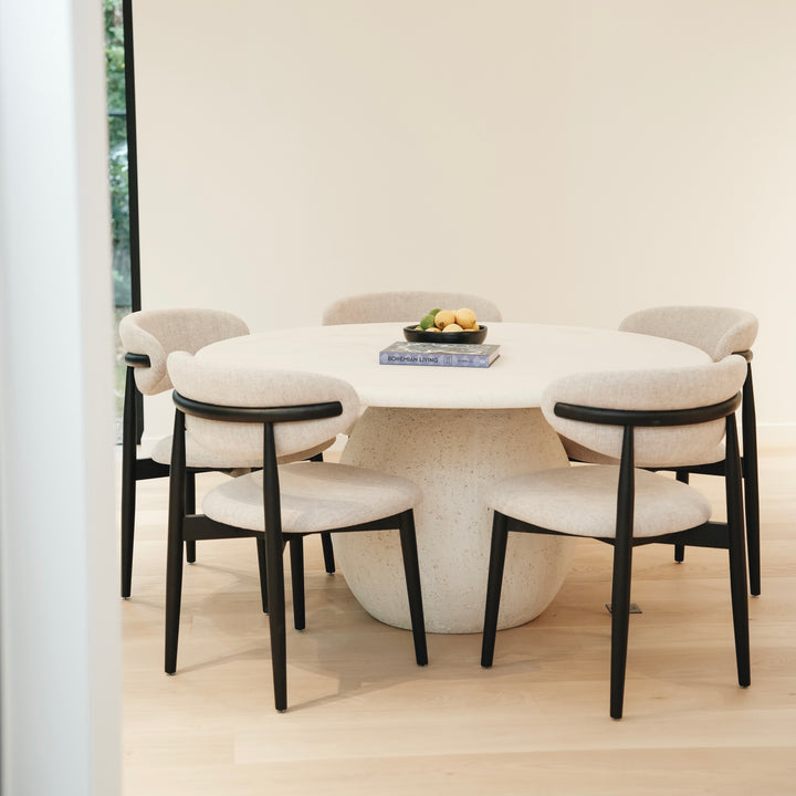 Set of Mowelli Dianne dining chairs in black wood and cream fabric around a modern round table