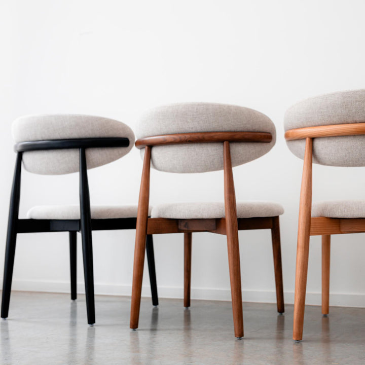 Mowelli Dianne dining chairs in black, walnut, and natural oak finishes lined up to show wood variations