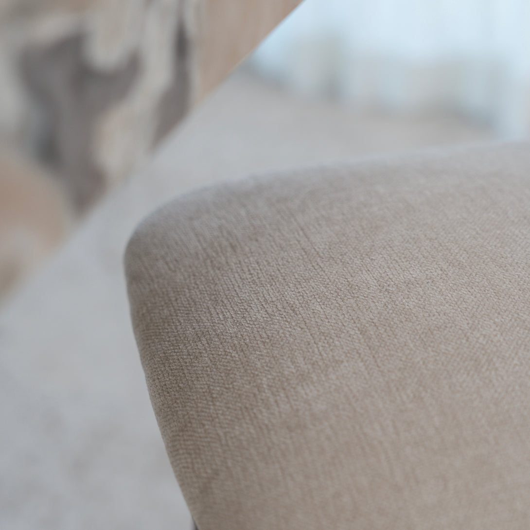 Macro detail of beige fabric texture on a Mowelli's Ella bar stool seat cushion.