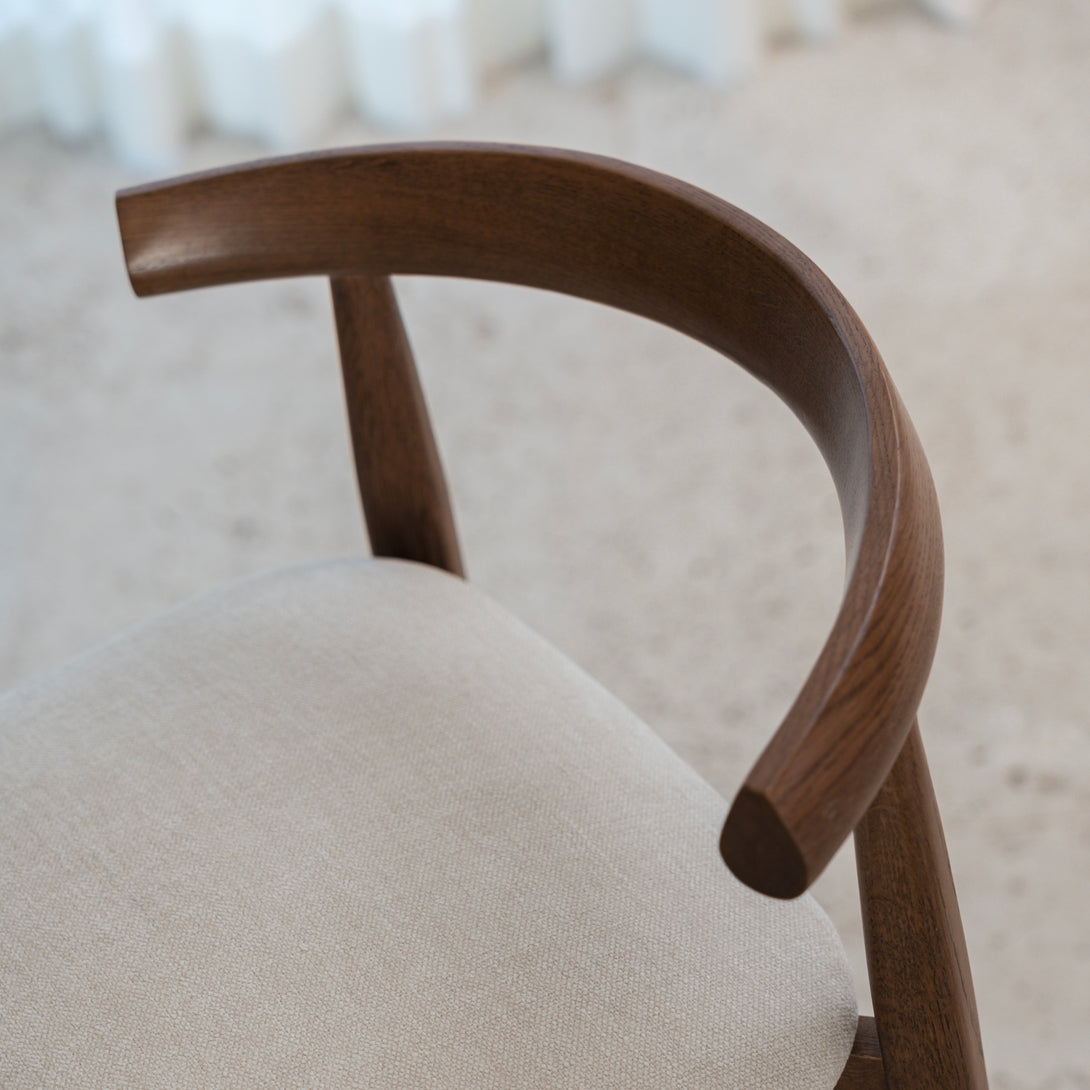 Top-down view of Ella bar stool by Mowelli in walnut finish with curved wooden backrest and neutral seat.