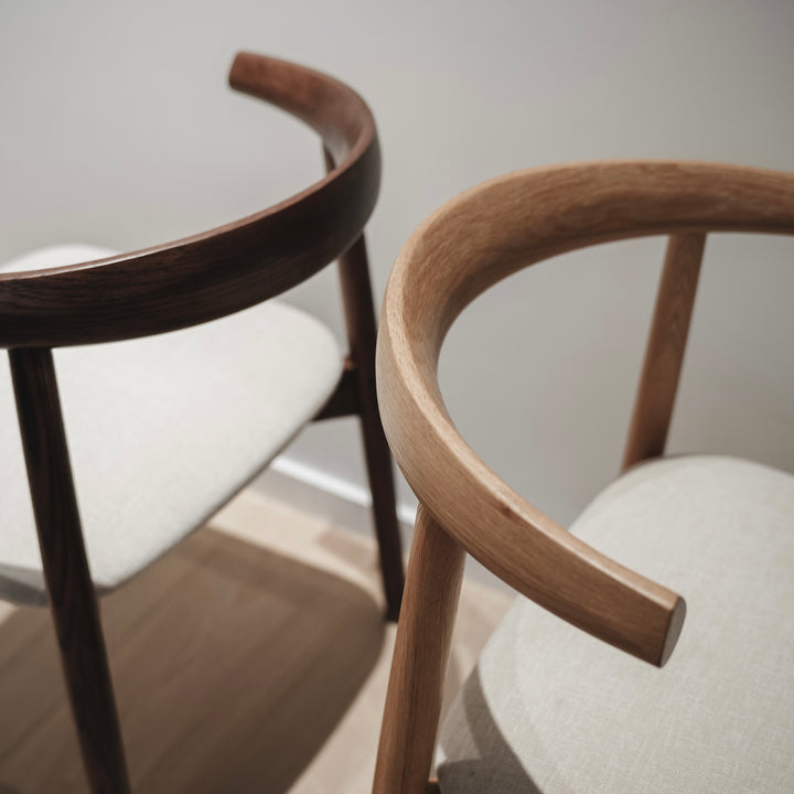 Comparison of Ella chairs by Mowelli in walnut and natural oak, highlighting wood tones and shape.