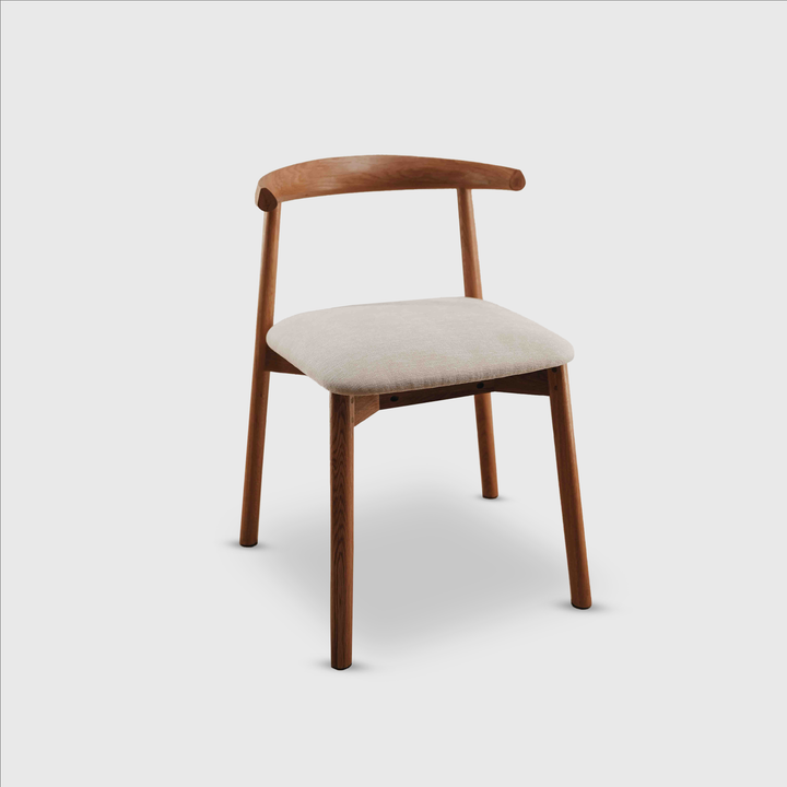 Studio image of the Ella dining chair by Mowelli in walnut wood with neutral upholstery