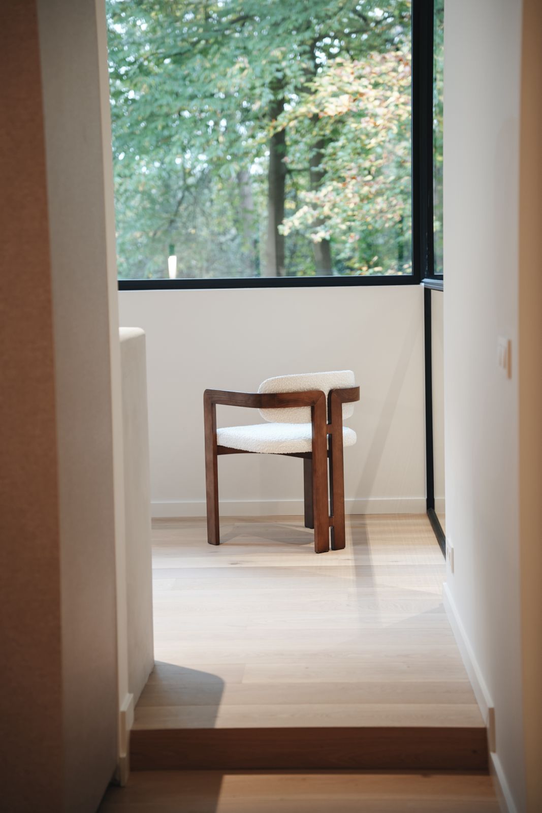 Minimalist Mila dining chair by Mowelli in a modern interior with natural wooden accents.