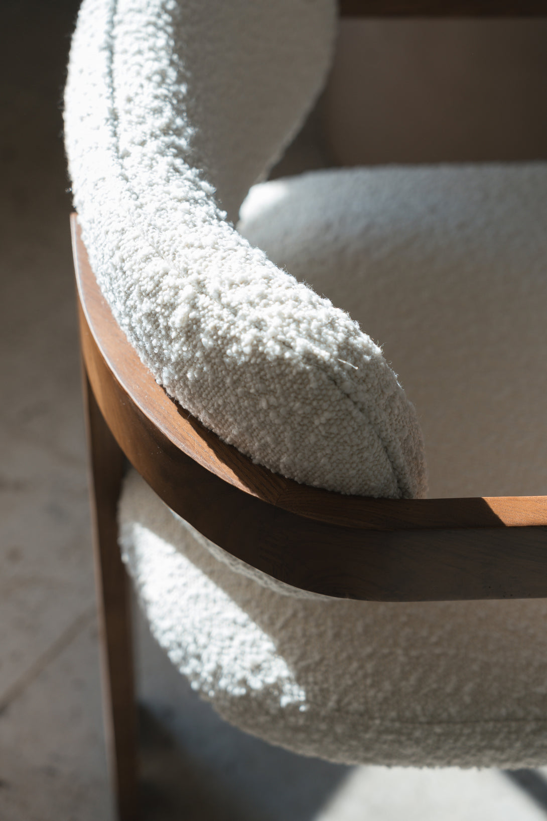 Close-up of the Mila dining chair by Mowelli, showing the soft bouclé backrest 