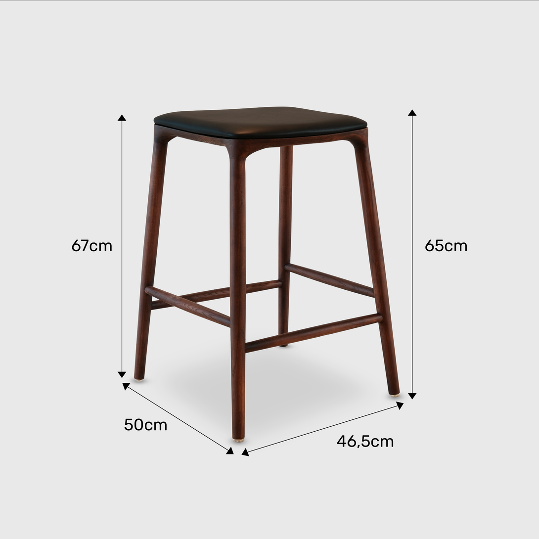 Mowelli Nora counter stool in brown walnut wood with premium vegan leather upholstered seat and minimalist backless design.