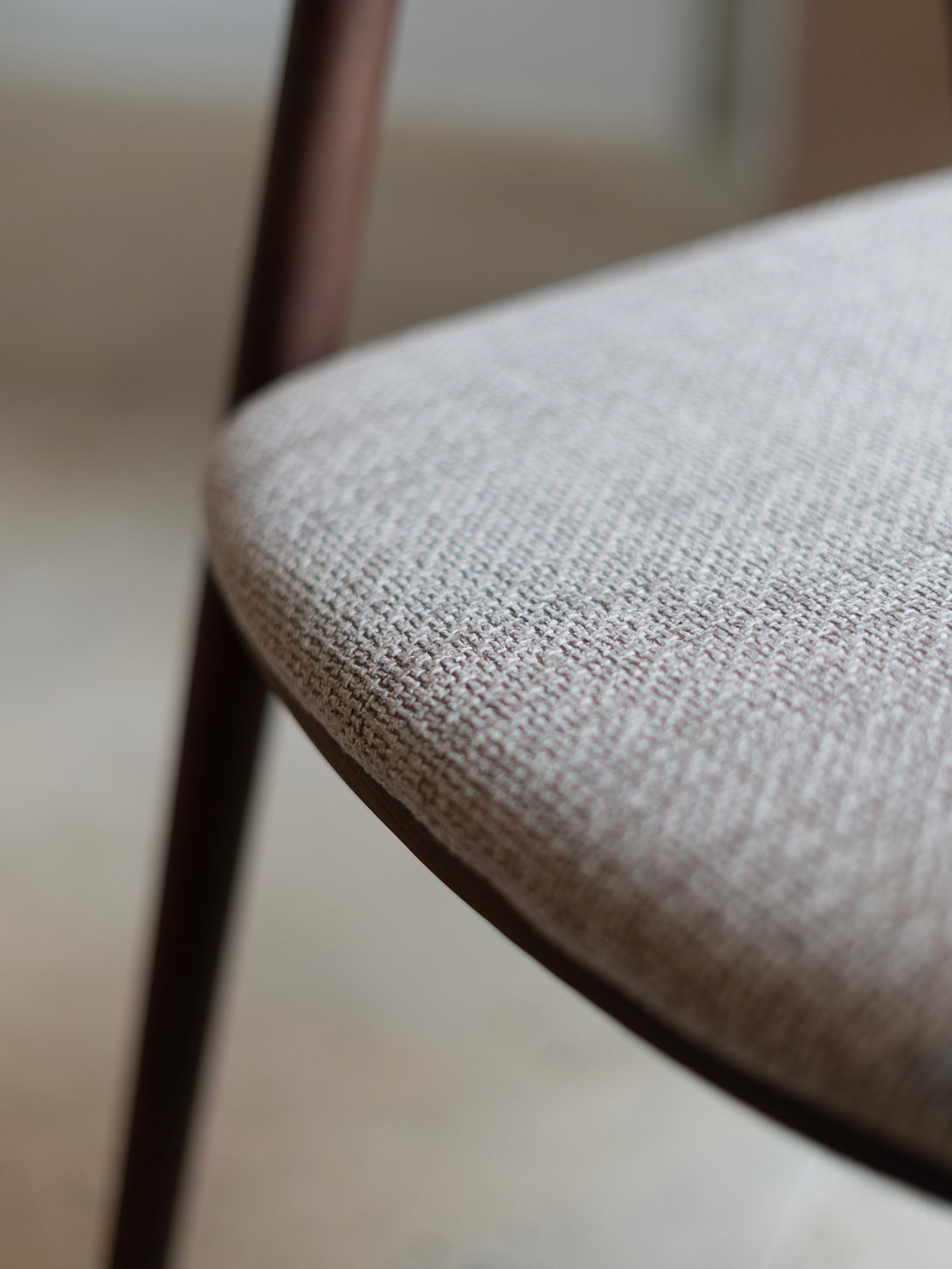 Nora comfort chair by Mowelli – stylish wooden chair in brown walnut with soft upholstered cushion seat, perfect for modern interiors.