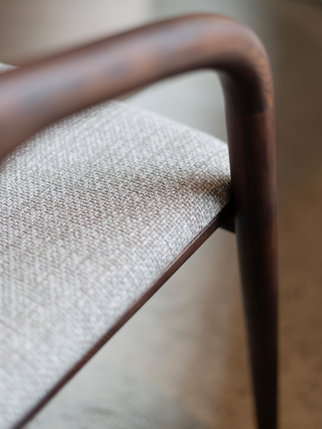 Nora comfort chair by Mowelli – stylish wooden chair in brown walnut with soft upholstered cushion seat, perfect for modern interiors.