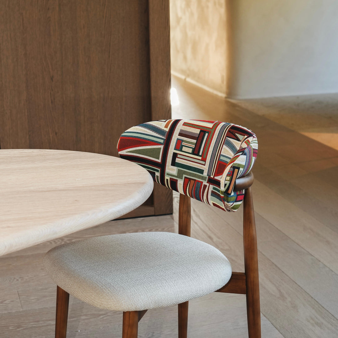 Multicoloured Mowelli x Rebo - Coco dining chair standing at a white minimalist table