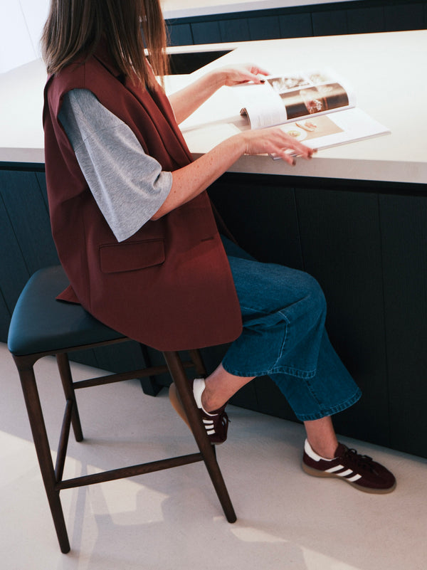 Mowelli wooden bar stool with black leather seat, handcrafted Belgian design used at modern kitchen island