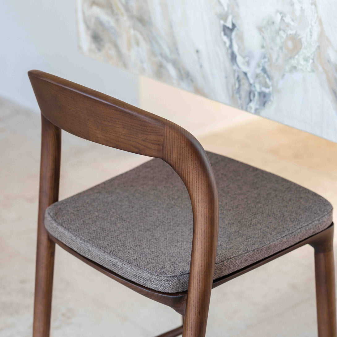 View from behind of a Nora bar stool with a mocha brown cushion standing at a kitchen island