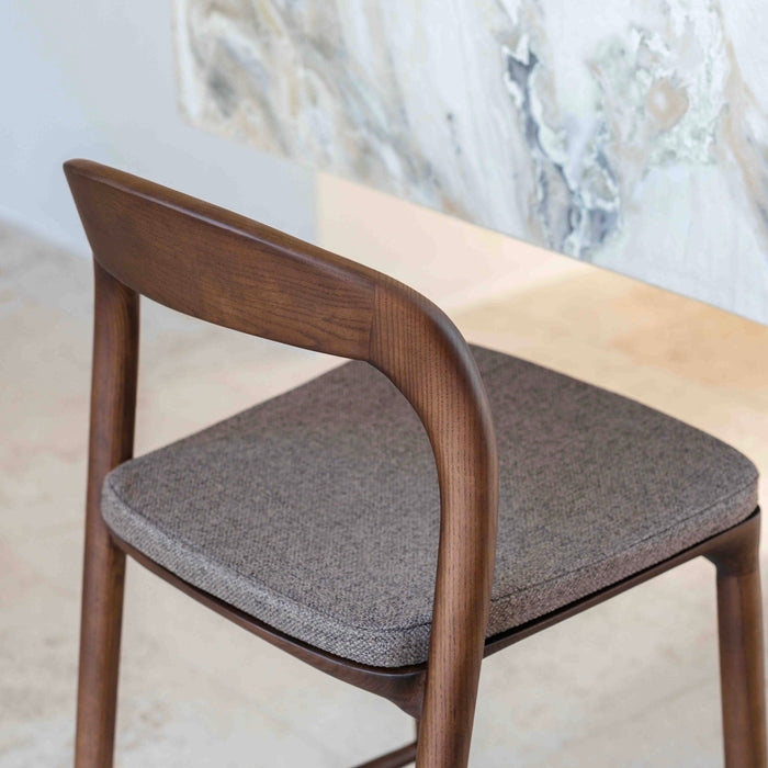 View from behind of a Nora bar stool with a mocha brown cushion standing at a kitchen island