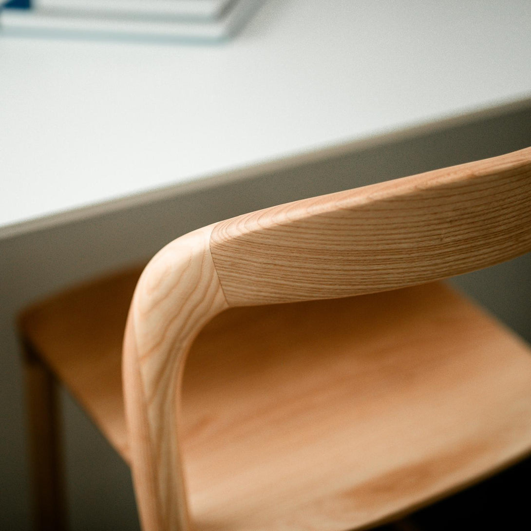 Detail of the curved natural ash wood backrest on the Nora bar stool by Mowelli – handcrafted eco-friendly seating