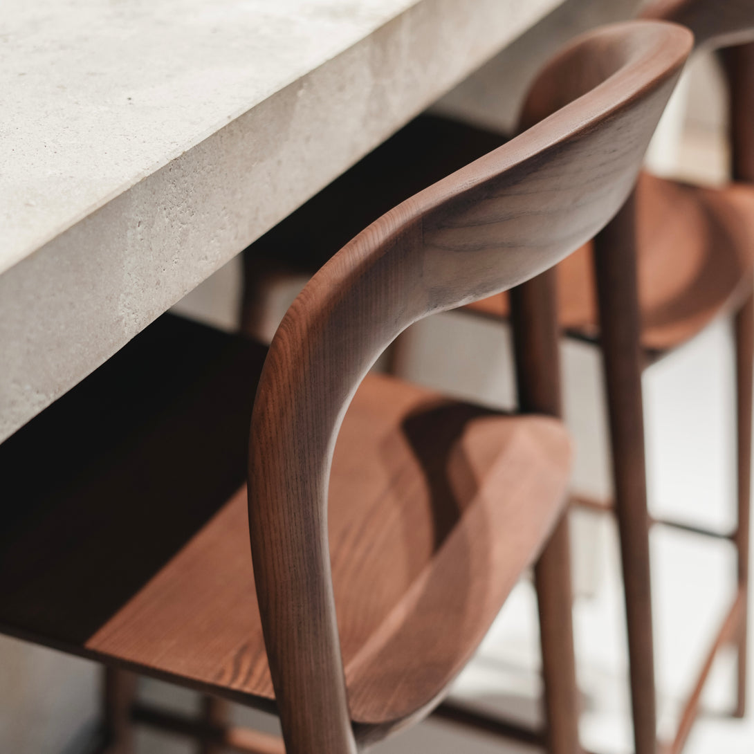 Detail of the curved backrest and joinery of a walnut Nora bar stool – Mowelli handcrafted wooden barstool