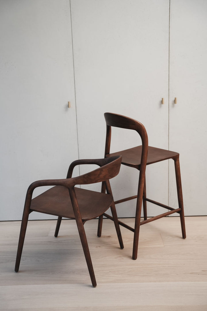 Matching set of a Mowelli Nora dining chair and a Nora bar stool in walnut wood with sculptural design