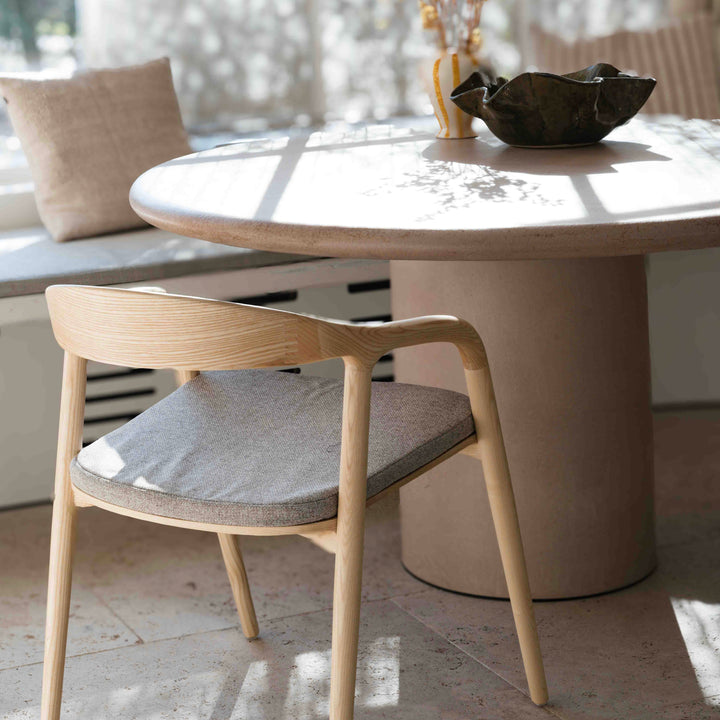 Mowelli Nora dining chair in natural ash wood with curved armrest and minimalist cushion design