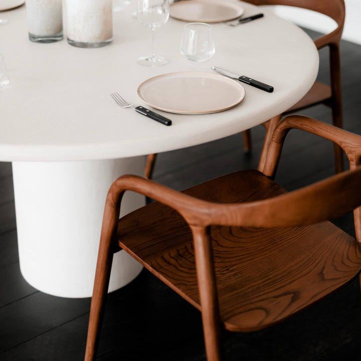 Walnut Mowelli Nora dining chair showcasing its curved wooden form, styled at a round white dining table, 