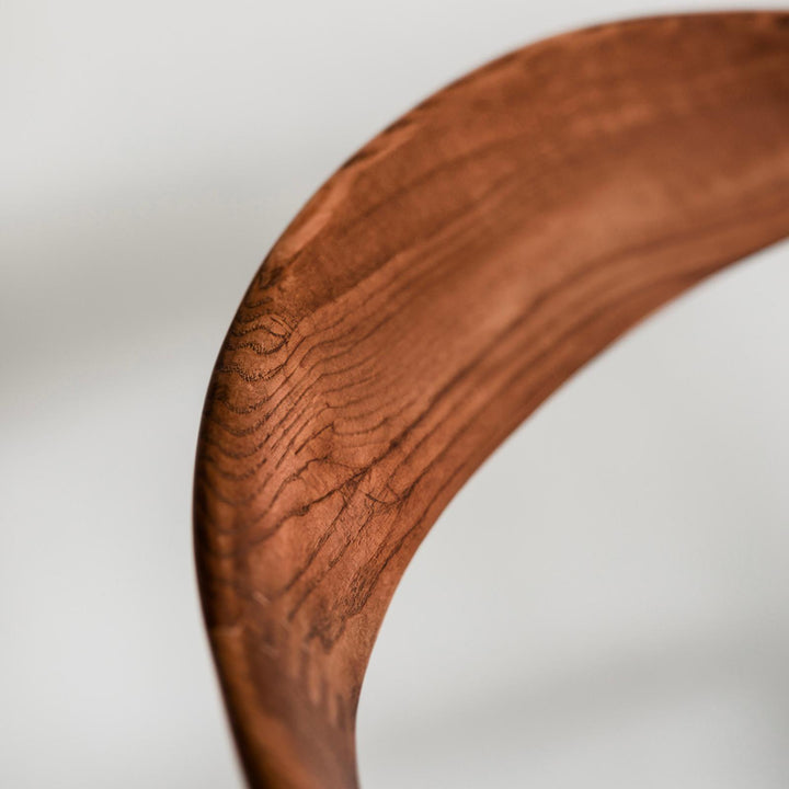 Detail of the walnut wood backrest on the handcrafted Nora dining chair by Mowelli.