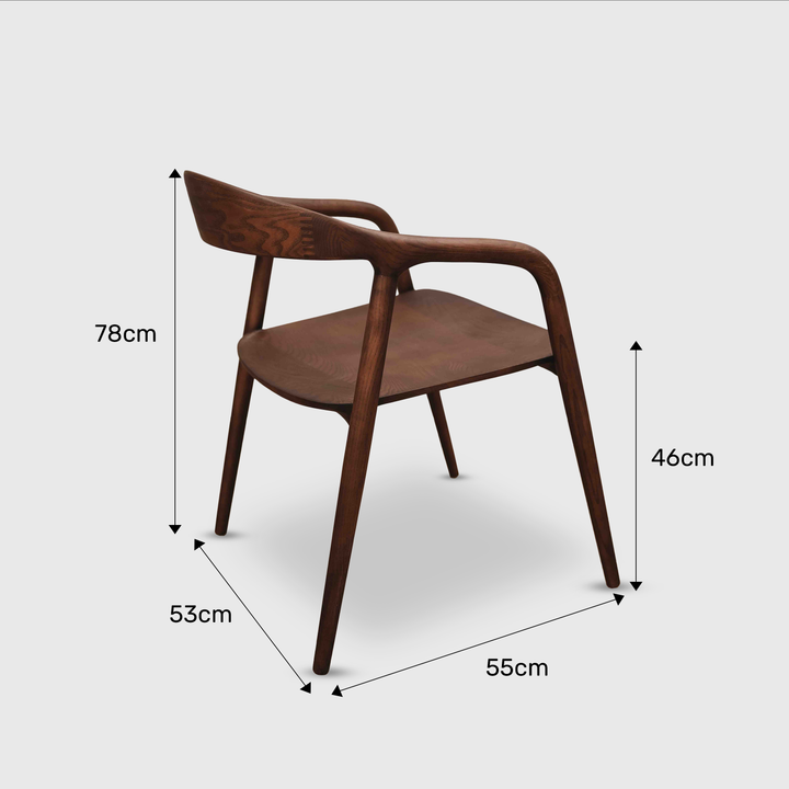 Walnut Mowelli Nora dining chair with armrests and dimensions shown in minimalist studio setting