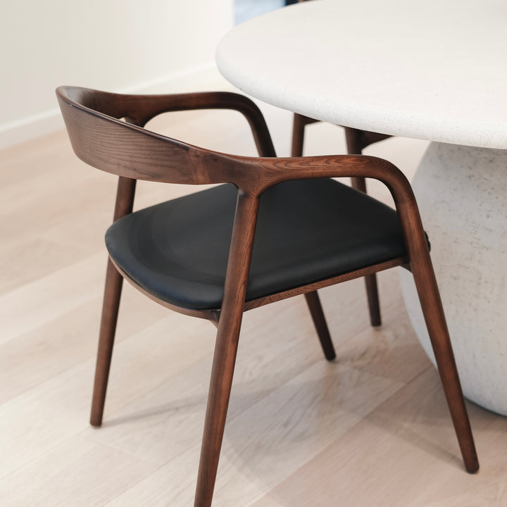 Side view of Nora leather seating chair by Mowelli with ash wooden frame in walnut colour and eco-friendly leather seating. 