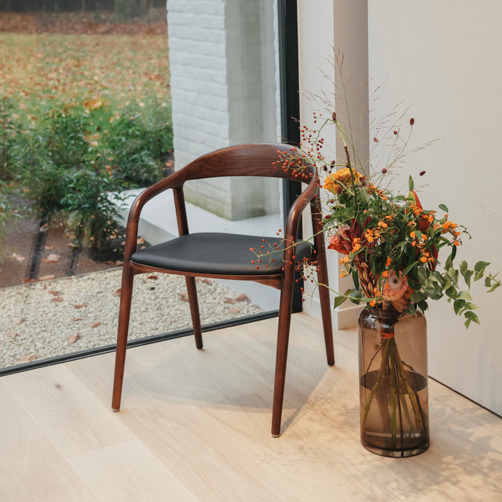 Front view of Nora leather seating chair by Mowelli featuring sustainable wooden frame and black leather seat.