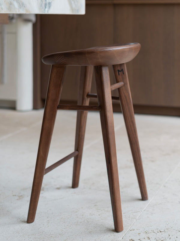 Productshot of Ollie bar stool from aside in dark walnut finish by Mowelli
