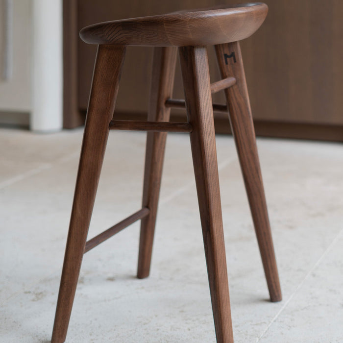 Productshot of Ollie bar stool from aside in dark walnut finish by Mowelli