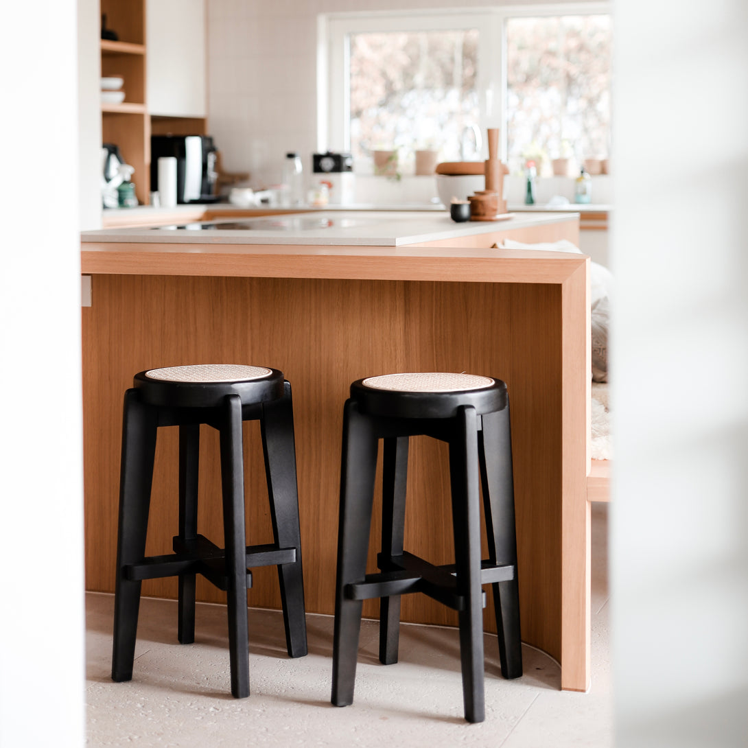 Two Pablo black bar stools standing at a kitchen island, next to each other