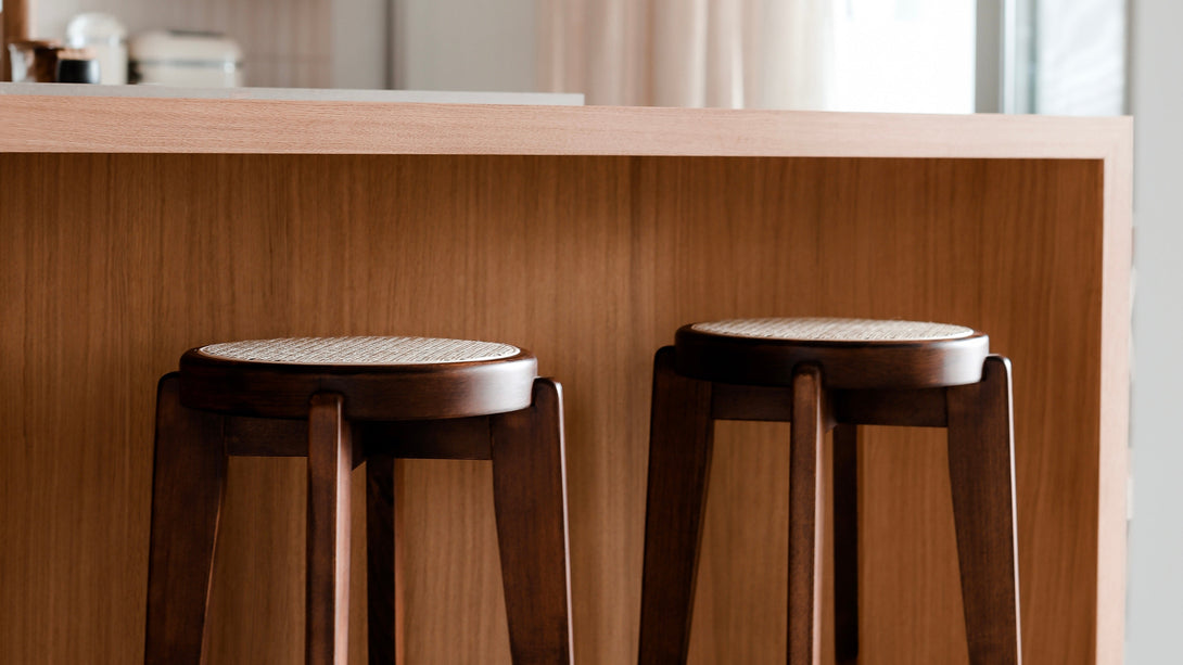 Two Pablo walnut bar stool standing at a kitchen island, next to each other