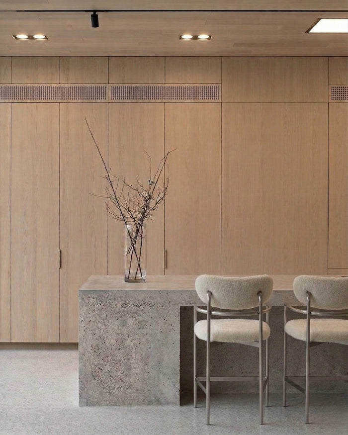 t4option0_0 | Coco bar chairs in ivory textured upholstery with brushed stainless steel frames in a minimal kitchen interior