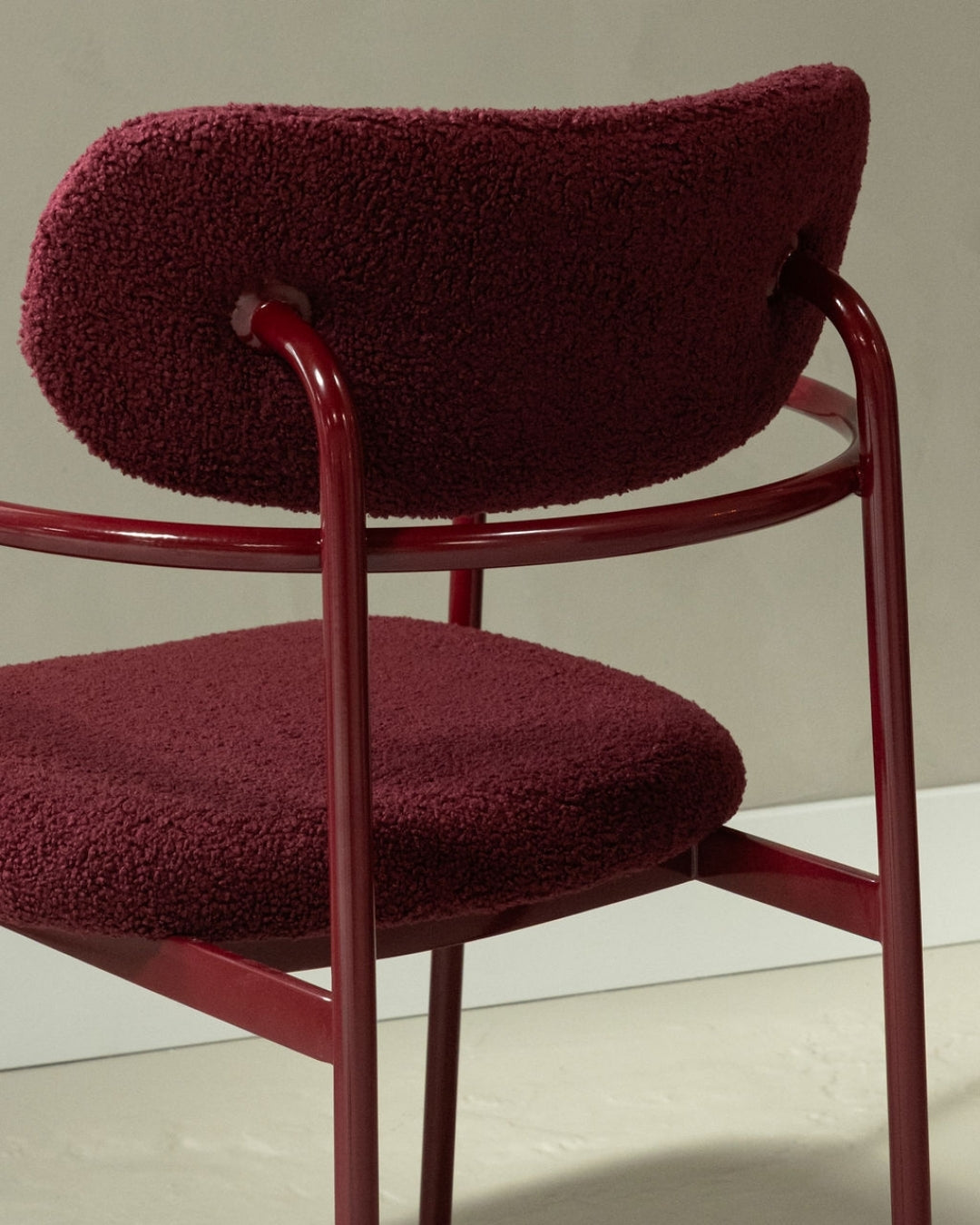 Close-up of Coco dining chair in burgundy upholstered fabric with matching frame showing texture and finish