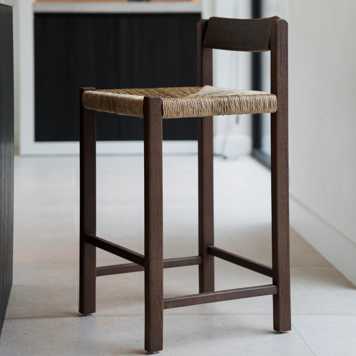 leo barstool made of solid hevea wood with handwoven rush seat in rubwood brown at a kitchen island