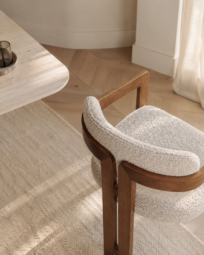 Close-up of the Mila dining chair showcasing its walnut wood frame and textured upholstery.
