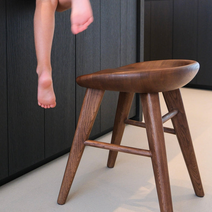 Ollie stools in walnut wood — minimalist design with soft curves and rich brown tones.