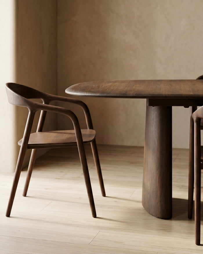 Detail of Mowelli Volta dining table in walnut with Nora dining chairs, showing conical pedestal leg and rounded table edge