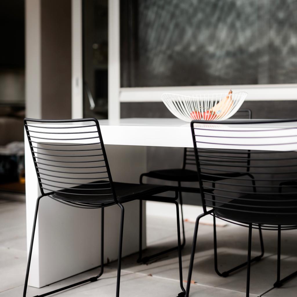 The back view of a Willow wire chair where you see the black and steel frame and backrest