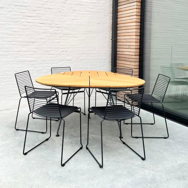 Six black Willow chairs by Mowelli standing at a wooden table